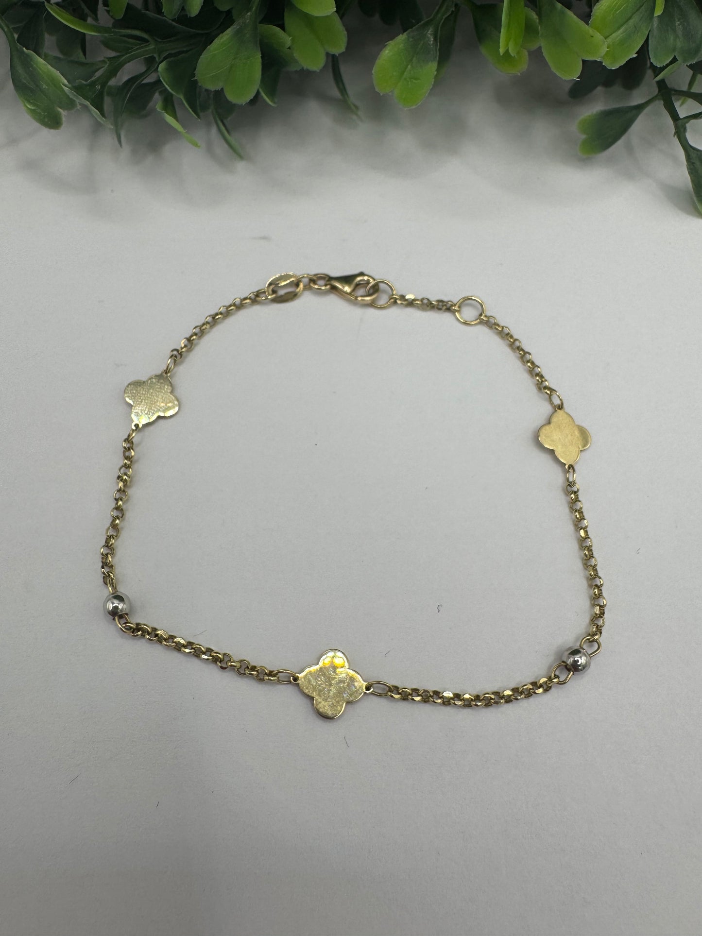 Pulsera rolo y clover dorados.
